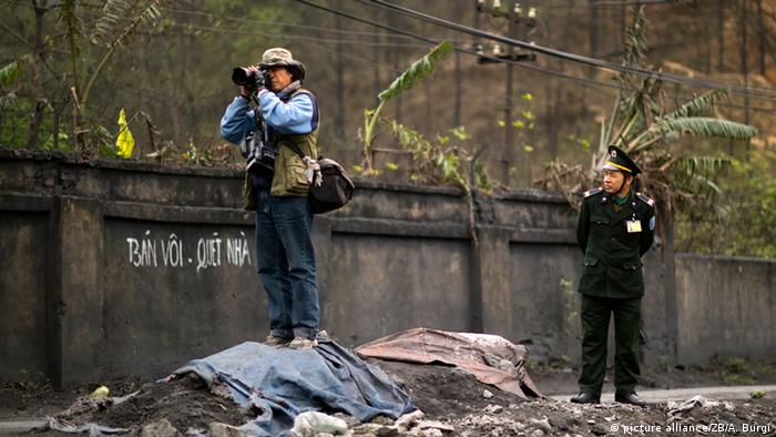 A Vietnamese soldier watches a photojournalist in action